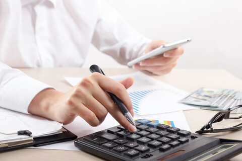 Close up of female accountant or banker making calculations. Savings, finances and economy concept