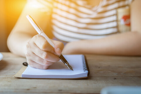 female hands with pen writing on notebook on wooden table ,young girl writing into her diary, in the park,Woman writing recipient address on mailing envelope,female hands sending letter,vintage color